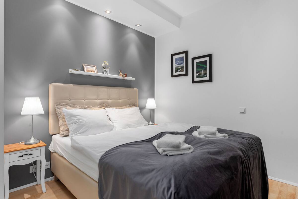 Ein Schlafzimmer mit einem Bett, Nachttischen und Wandregalen.