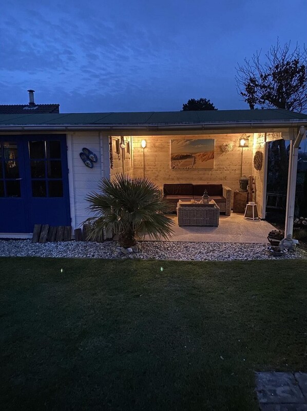 A house with a patio, a large painting, and a blue door.
