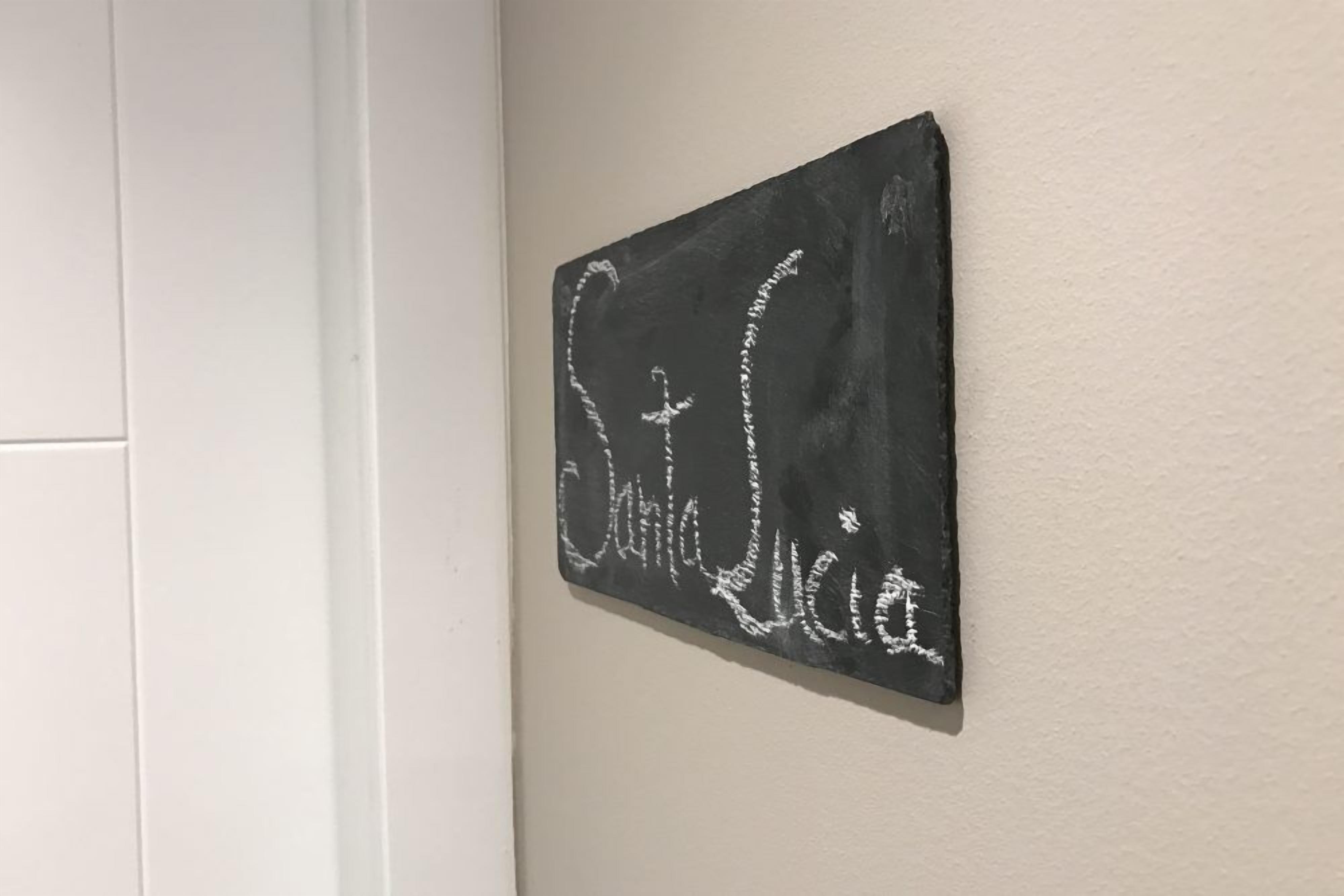 Un letrero de pizarra con el nombre 'St. Lucia' escrito, colgado en una pared.