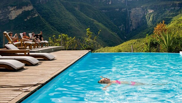 A swimming pool with lounge chairs and a mountainous backdrop. - Gocta Andes Lodge (Cocachimba)