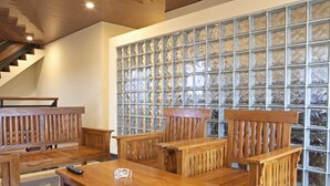A wooden dining area with a glass partition wall. - RedDoorz near Trans Studio Mall 2 (Bandung)