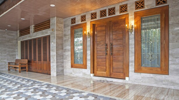 A spacious lobby with large wooden doors, a patterned floor, and a bench. - RedDoorz near Trans Studio Mall 2 (Bandung)