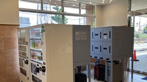 A self-service locker area with a vending machine, luggage storage, and a view of the outside. - Toyoko Inn Shonan Kamakura Fujisawa Station Kita (Fujisawa)