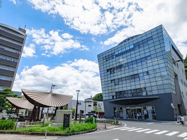 A modern building with a glass facade and a large entrance.