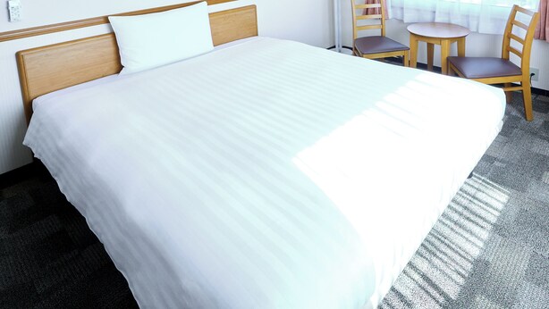 A hotel room with a large bed, a desk with a chair, a lamp, and a window with curtains. - Toyoko Inn Tokushima Station Bizan (Tokushima)