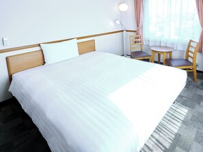 A hotel room with a large bed, a desk with a chair, a lamp, and a window with curtains. - Toyoko Inn Tokushima Station Bizan (Tokushima)