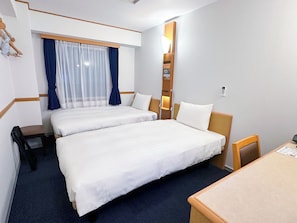 A hotel room with two beds, a desk, a chair, a nightstand, a lamp, and a window with curtains. - Toyoko Inn Hanshin Amagasaki Ekimae (Amagasaki)