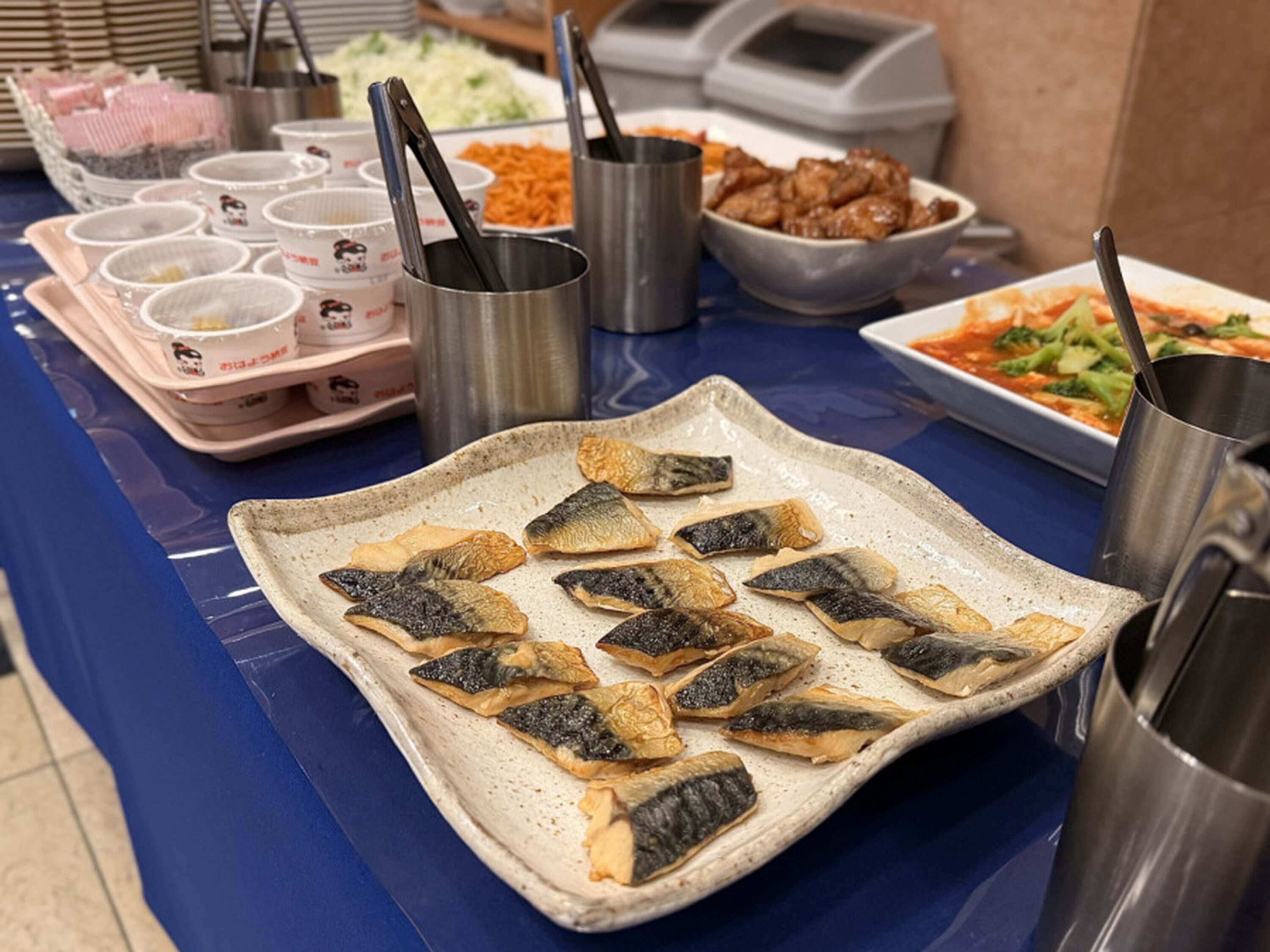 Ein Buffet mit verschiedenen Speisen, darunter Fischteller, Suppenschalen und weitere Gerichte.