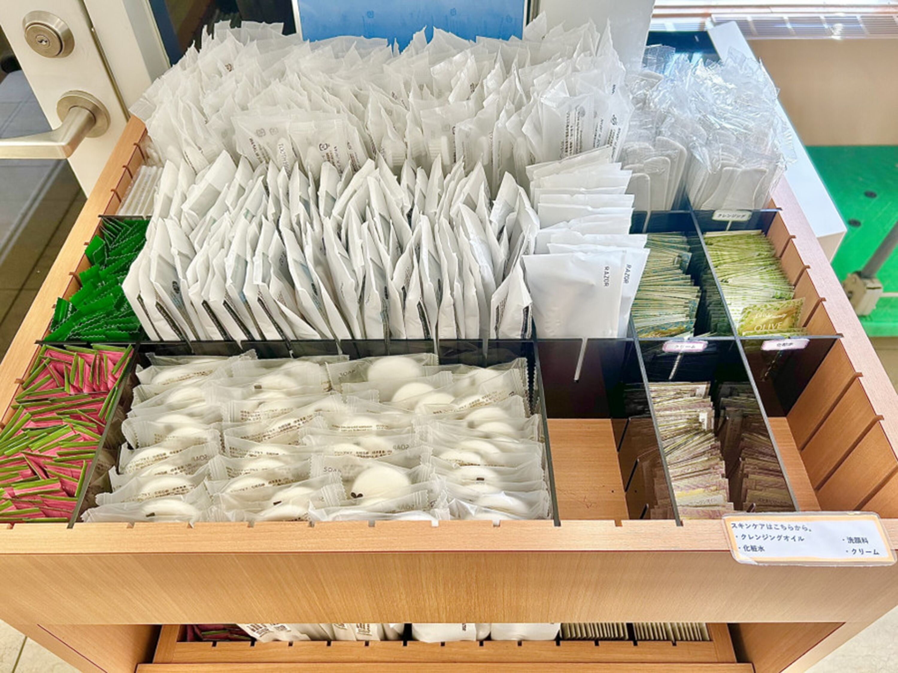 A storage area with various packaged items, including white and green packages, and a sign with Japanese text.