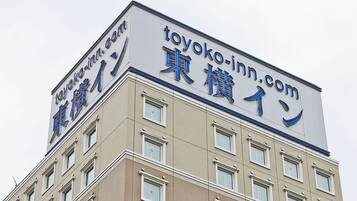 A building with a sign that reads "toyoko-inn.com" in both English and Japanese.
