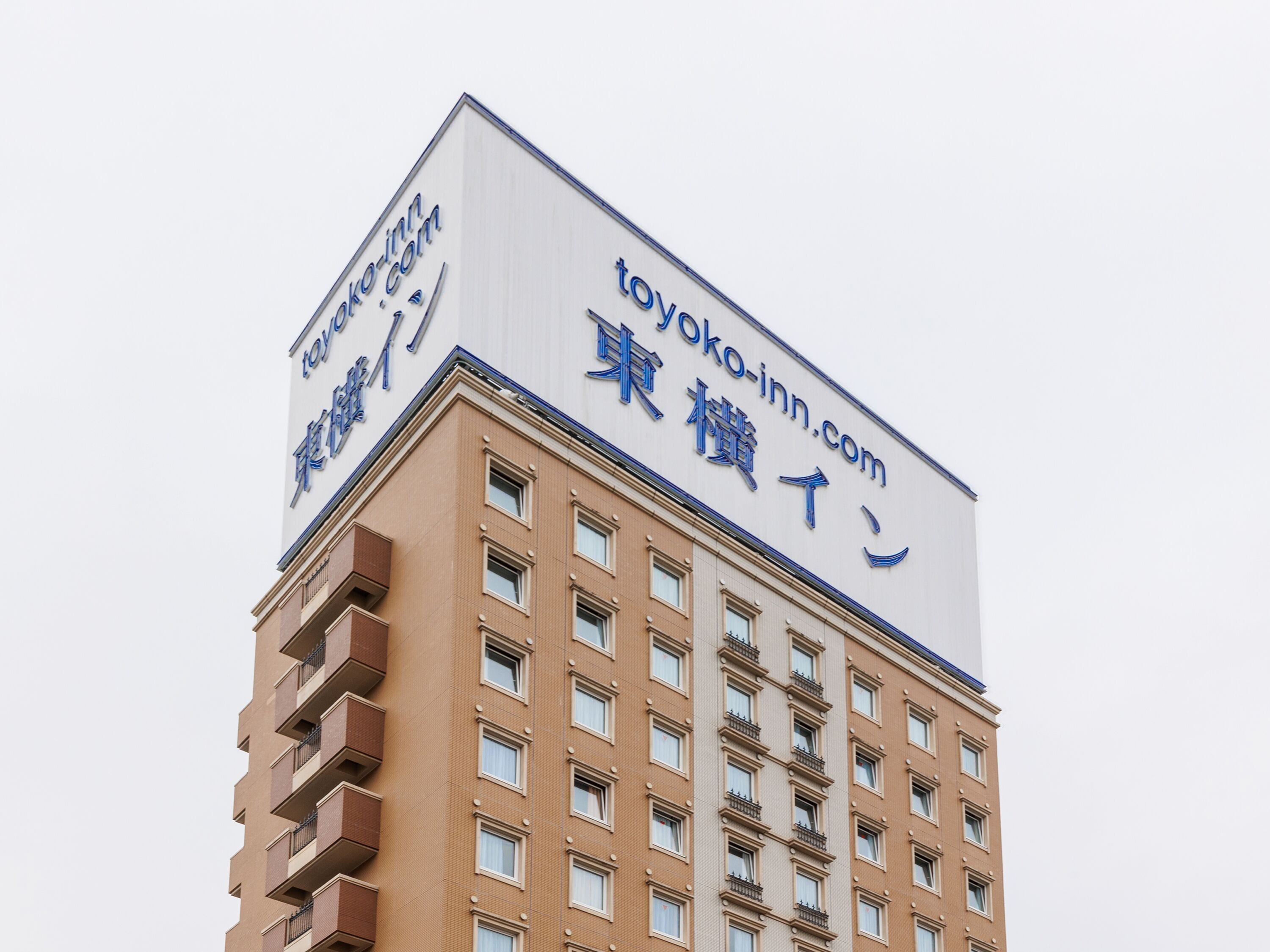 A building with a large sign advertising 'toyoko-inn.com'.