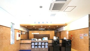 Un espace d’accueil comprenant un comptoir, un extincteur et un kiosque en libre-service.