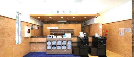 A reception area with a counter, a fire extinguisher, and a self-service kiosk.