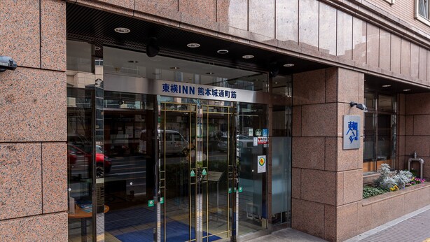 L’entrée d’un immeuble avec une enseigne indiquant « 東横INN ».