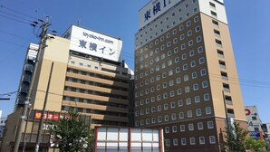 En flervåningsbyggnad med skyltar för ”Toyoko Inn” och ”Toyoko Inn Tokyo”.