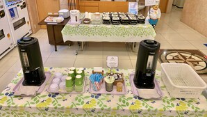 Ein reichhaltiges Buffet mit Kaffeeautomaten, Einwegbechern und Speisebehältern.