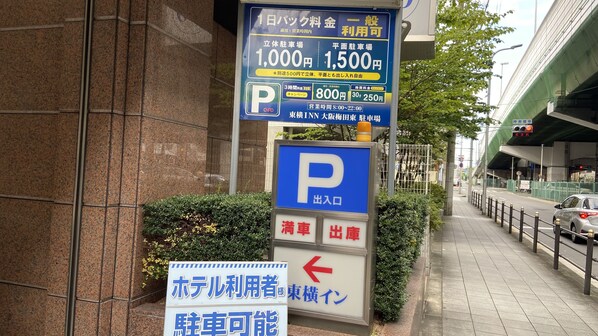 A parking sign with rates for parking spaces and a directional sign for hotel users. - Toyoko Inn Osaka Umeda Higashi (Osaka)