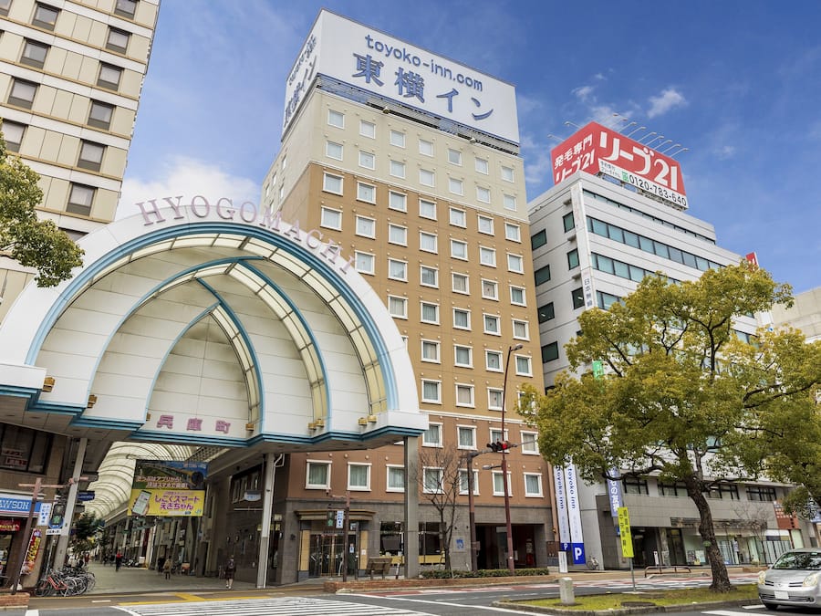 Un hotel con una entrada de arco destacada, un letrero que dice 'Toyoko Inn' y un letrero que indica 'Hyogoma'.