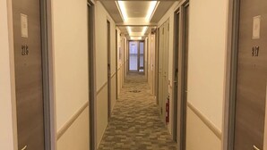 A hotel hallway with carpeted floors, doors numbered 218 and 217, and a fire extinguisher on the wall. - Toyoko Inn Takamatsu Hyogomachi (Takamatsu)