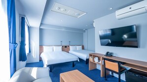 Ein Hotelzimmer mit zwei Betten, einem Schreibtisch, einem Stuhl, einem Fernseher und einer Klimaanlage.
