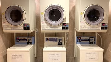 Three rows of CO/N DRYER 45 machines with washing machines below them, each with a control panel and a note on the wall.