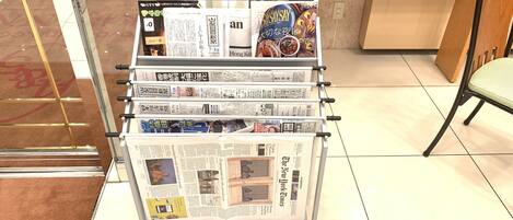 Un mostrador de exhibición con varios periódicos y revistas.