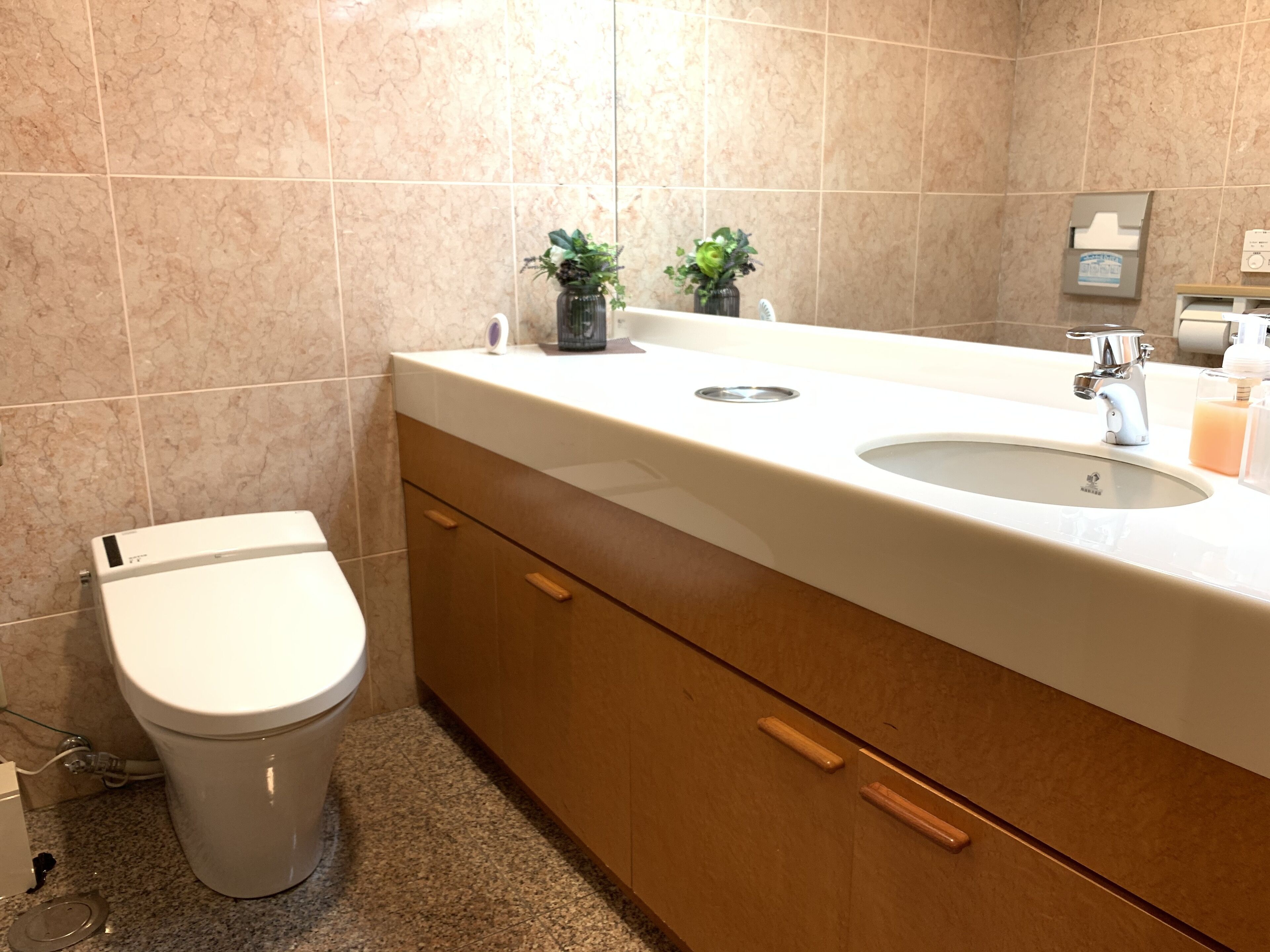 A bathroom with a toilet, a sink, and a cabinet.
