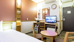 Habitación de hotel con cama, escritorio, silla y televisor que muestra una vista panorámica.