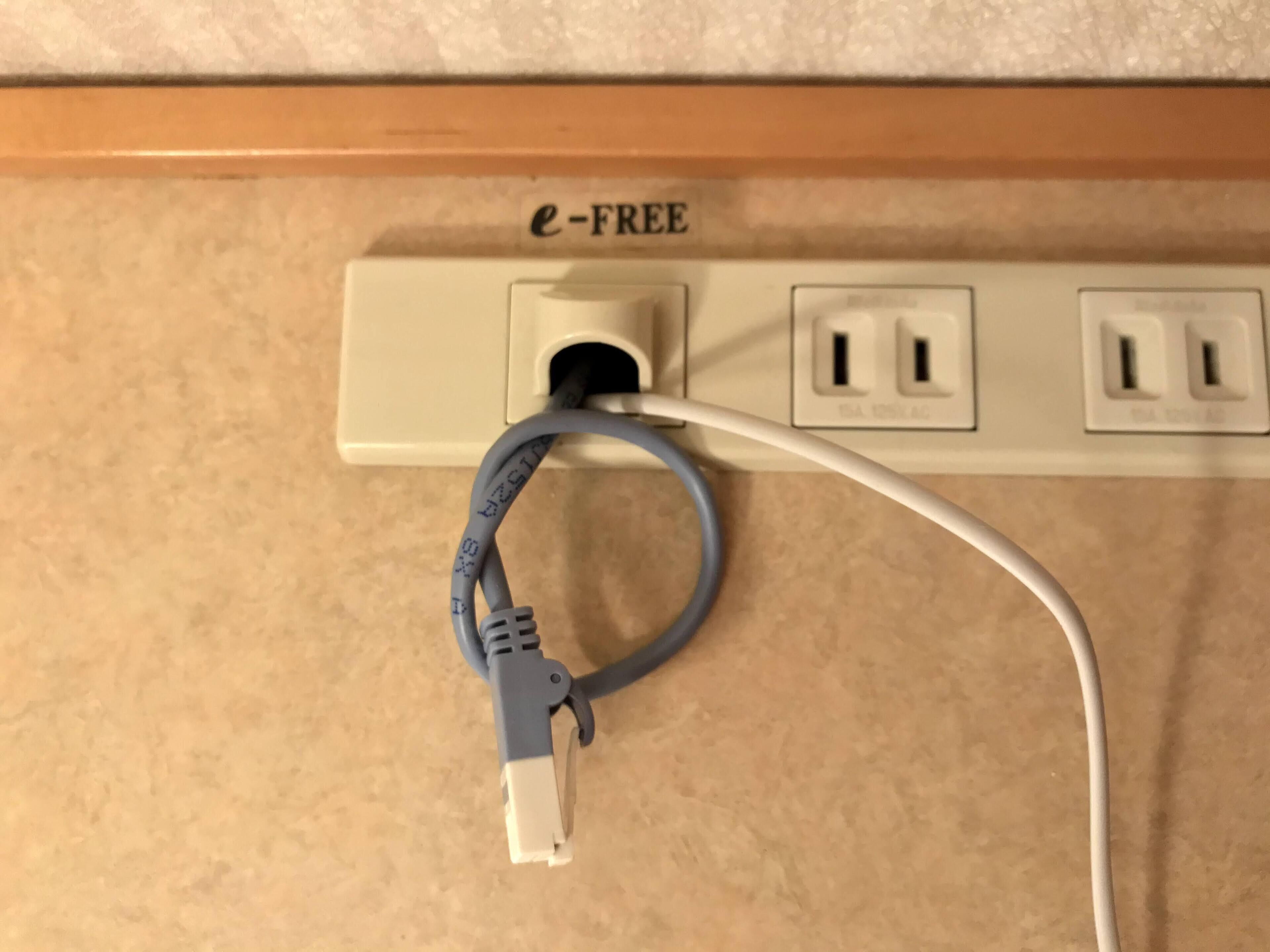 A power strip with a label reading "e-FREE" and a cable plugged into it.