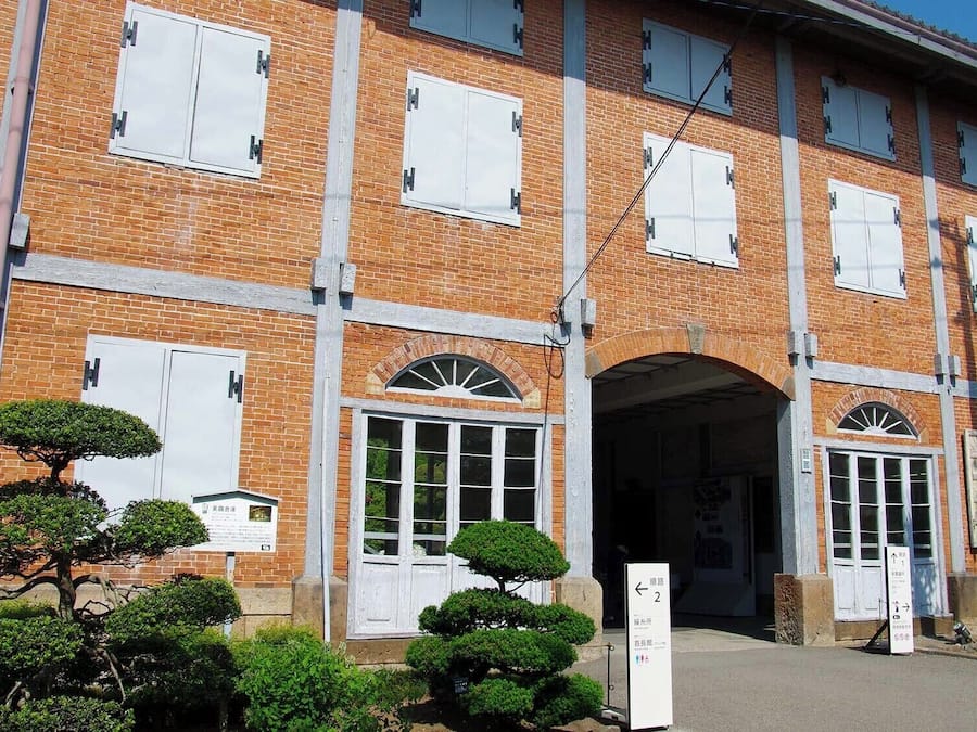 A multi-story brick building with white-framed windows and a central arched entrance.