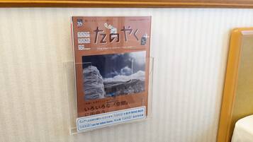 A framed poster on a wall with Japanese text and a mountain landscape.