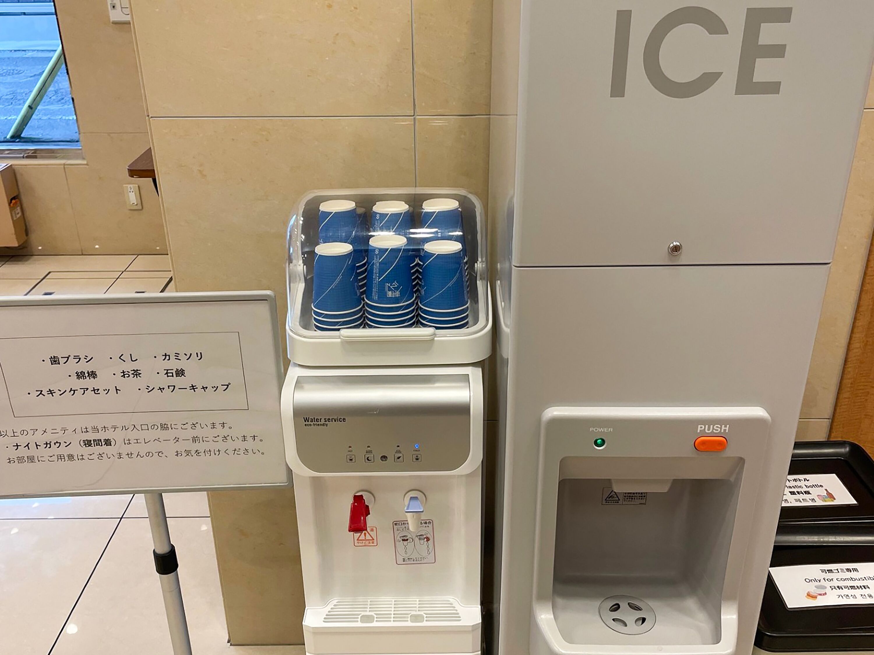 A water dispenser with a sign listing beverages and instructions in Japanese.