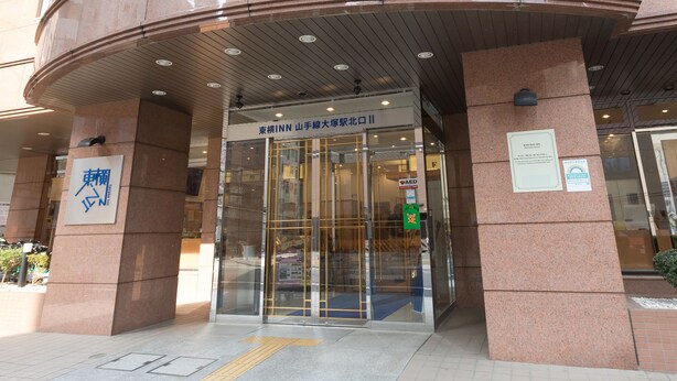 A hotel entrance with a curved facade, glass doors, and a sign indicating it is an Inn.