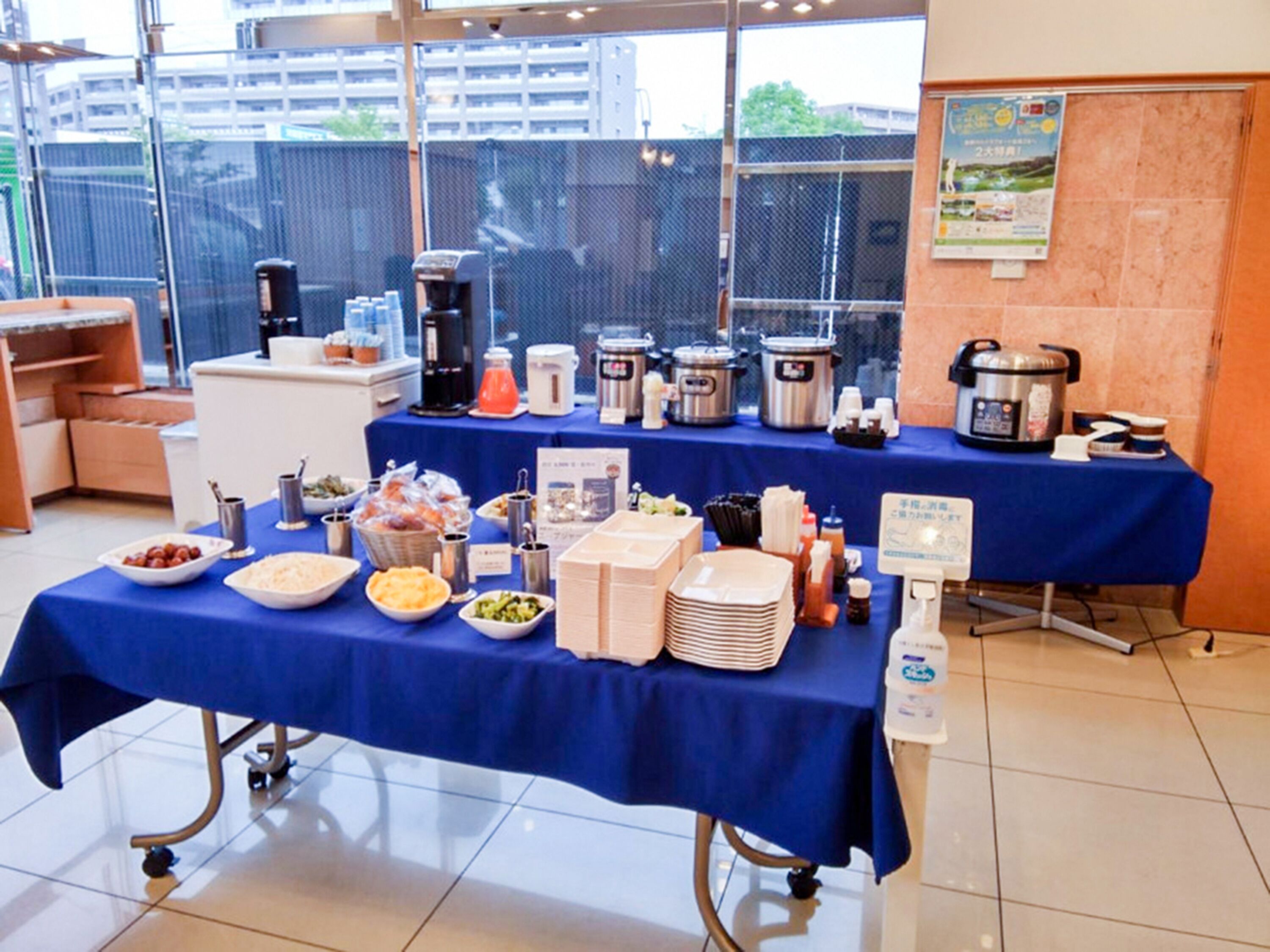 A buffet table with various food items and beverages, a coffee machine, and a slow cooker.