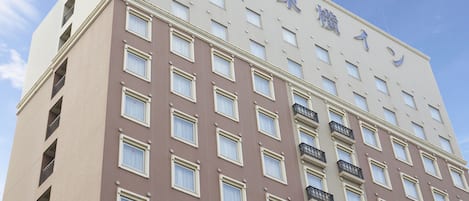A multi-story hotel building with a beige facade and numerous windows.