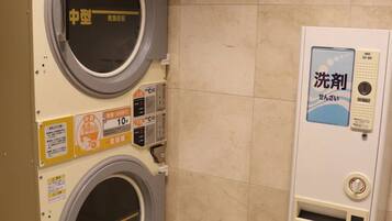 A laundry facility with two washing machines and a detergent dispenser.