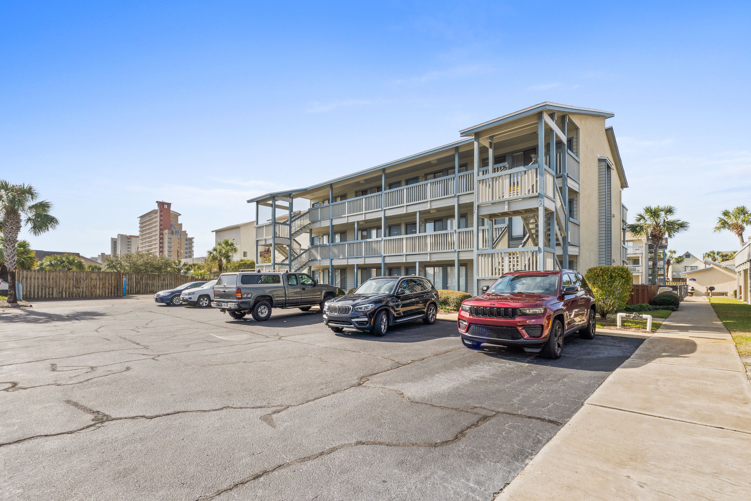 A multi-story residential building with a parking lot.