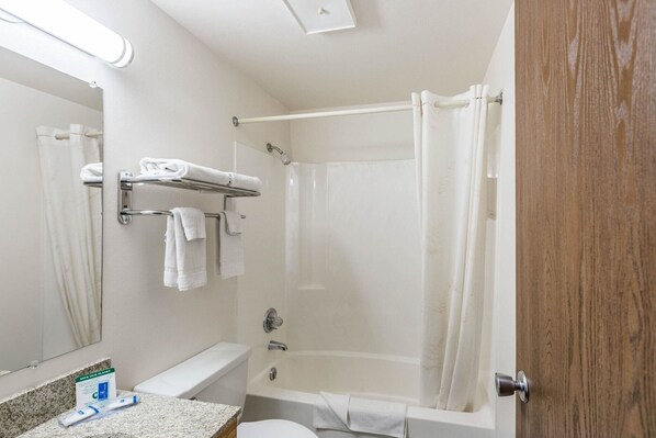 Une salle de bain avec douche, toilettes et lavabo.