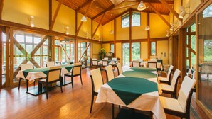 A spacious dining area with wooden beams, large windows, and tables set for dining. - Pica Yamanakako Village (Yamanakako)