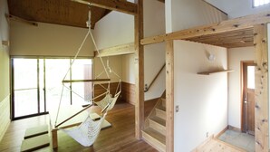 A room with a wooden floor, a hammock, a staircase, and a door. - Pica Yamanakako Village (Yamanakako)
