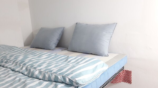A bed with striped bedding and two pillows.