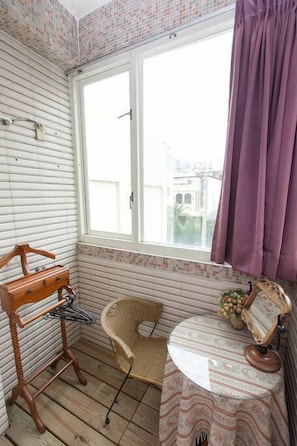A small room with a window, a chair, a table, and a wooden hanger. - Ocean Lover Homestay (Hualien City)