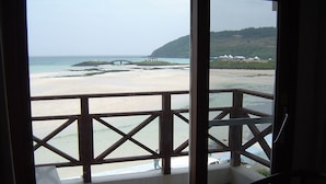 Un balcón con vista a una playa y un puente.