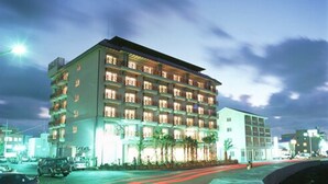 Un hotel de varios pisos con techo plano y numerosas ventanas.