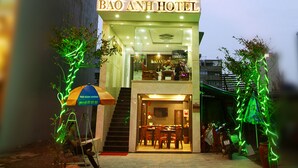 Un hotel de varios pisos con un cartel que dice "BÁO ANH HOTEL" en la entrada.