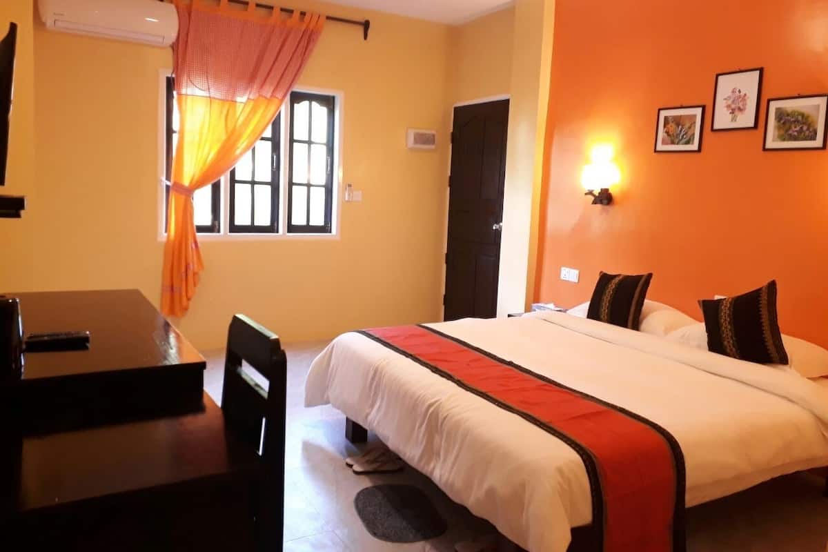 A hotel room with a bed, a desk, and a chair.