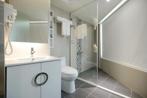 A modern bathroom with a toilet, sink, and shower area.