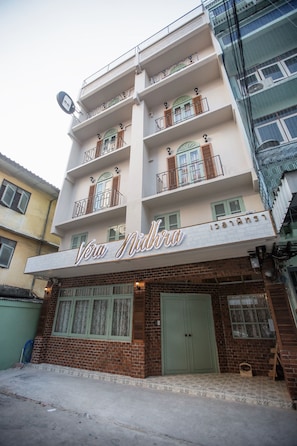 A building with a sign reading "Vera Nidhra" and a brick facade.