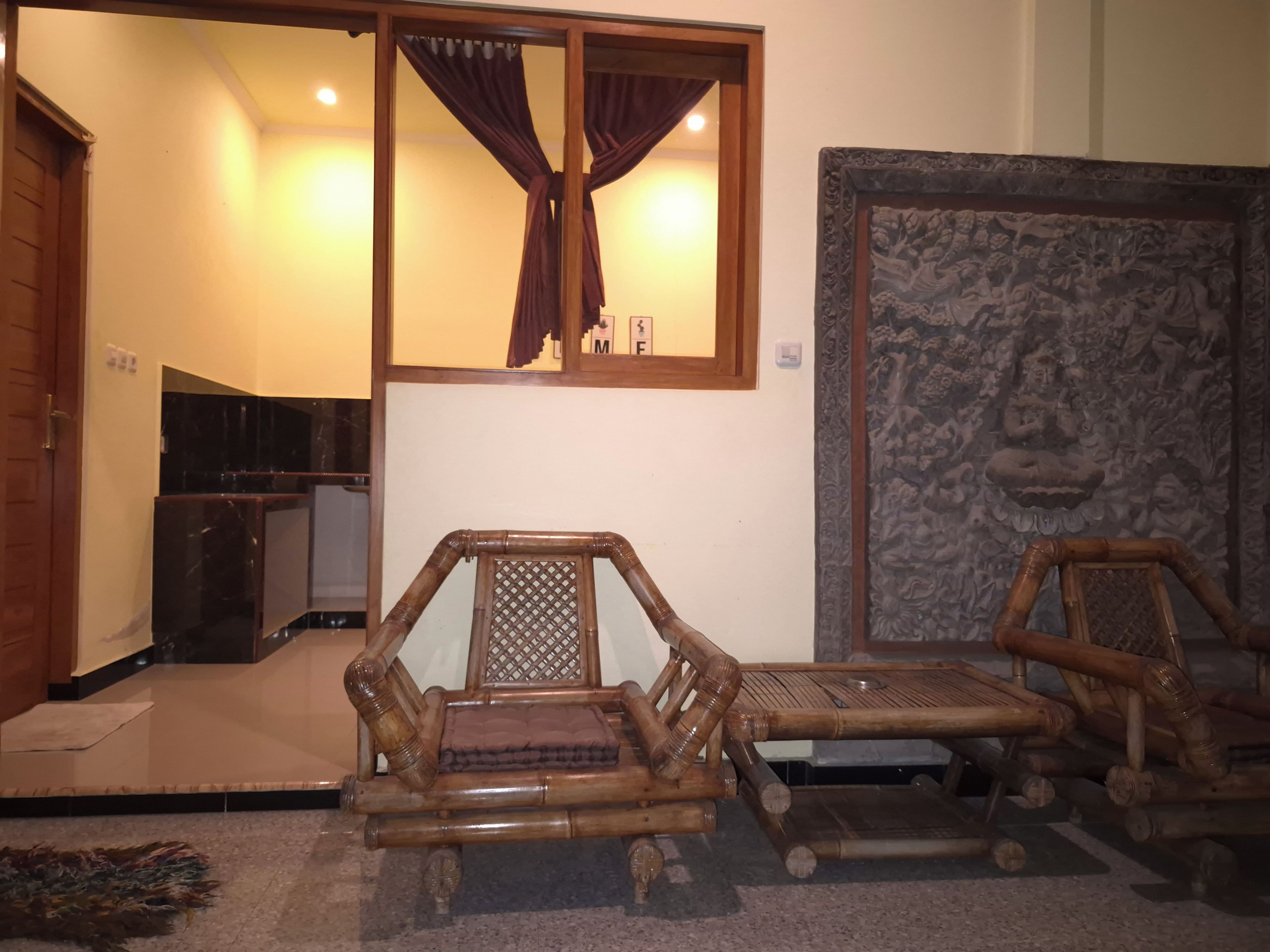 Une pièce comprenant une chaise en bois de style traditionnel, une petite table et un élément décoratif mural.
