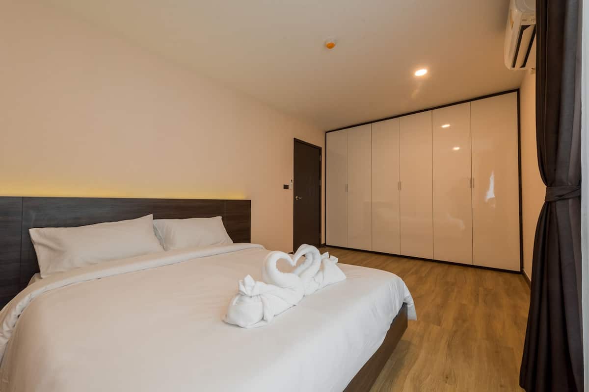 Une chambre d’hôtel avec un lit bien fait, une armoire et une porte.